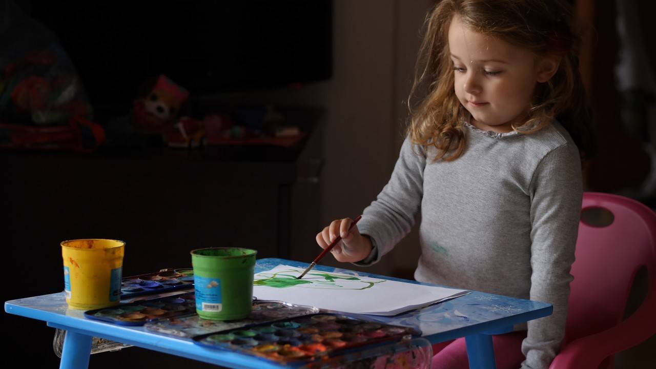 criança de 4 anos pintando em uma mesa