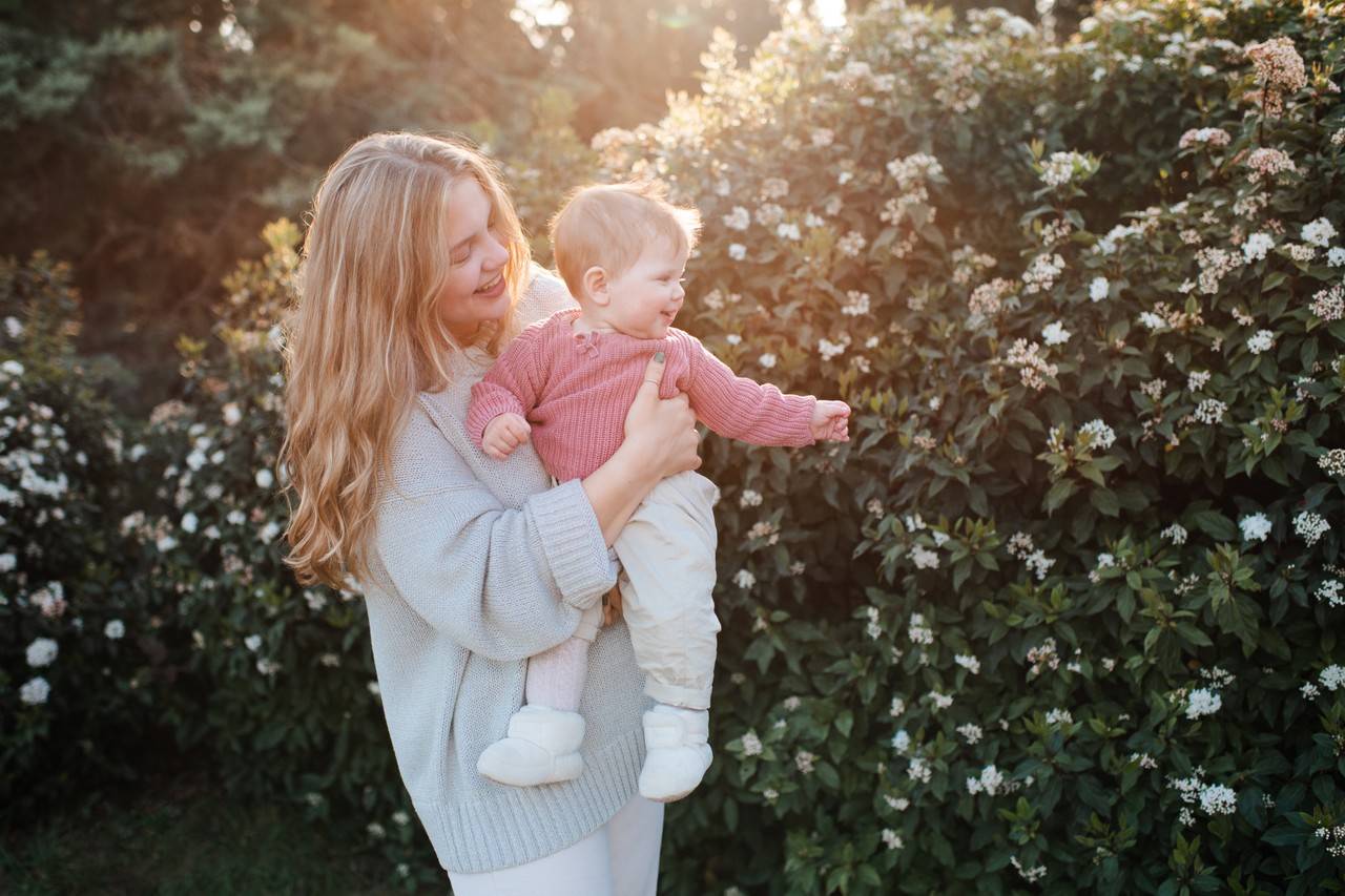 mãe e filha de origem grega passeando pelo jardim cheio de flores brancas