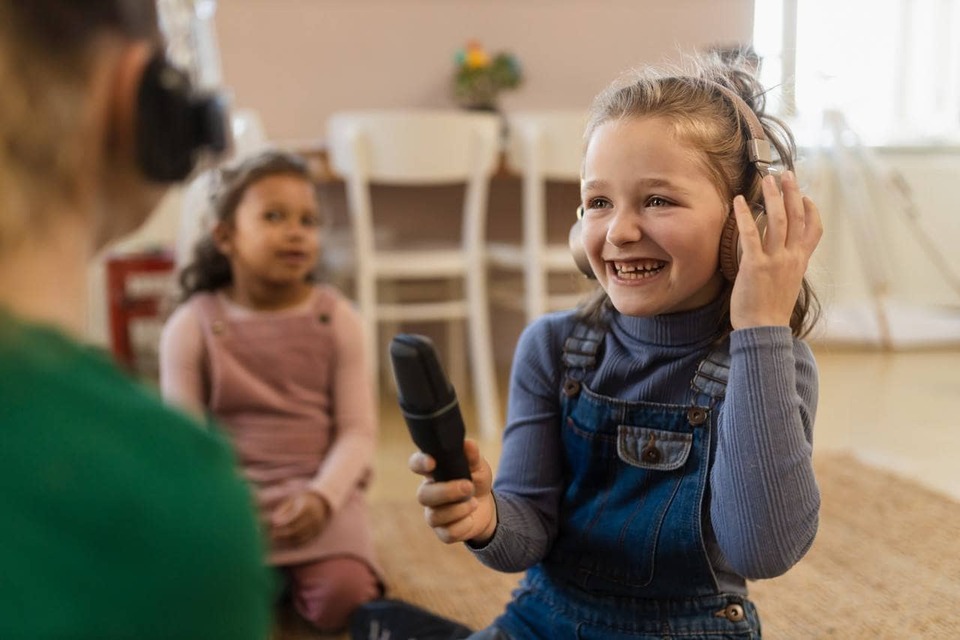  meninas com fones de ouvido e microfone entrevistando o pai